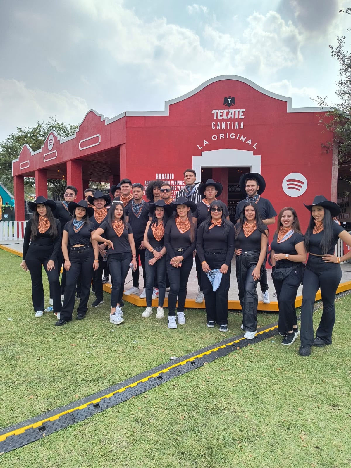 Equipo frente al espacio de Tecate en un evento.