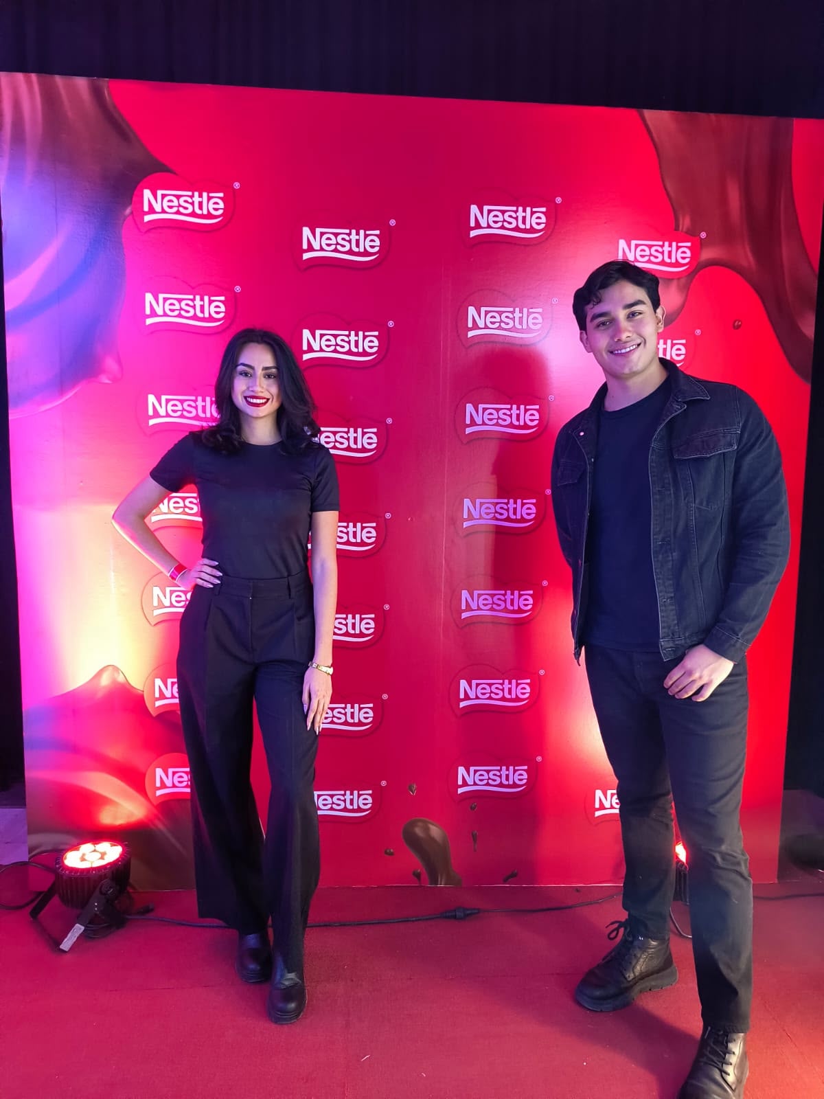 Dos personas frente a un fondo de Nestlé.
